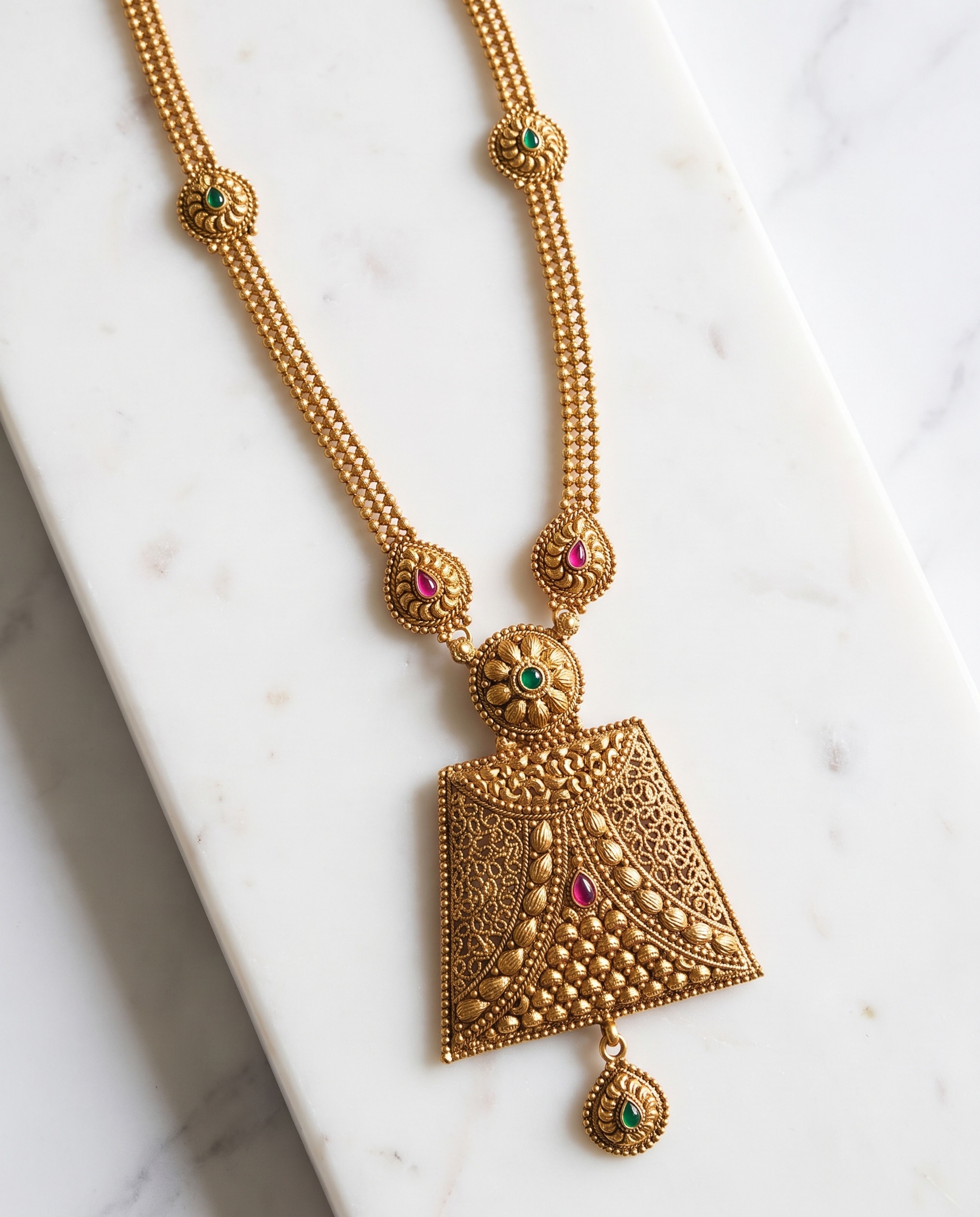 Antique Double-Strand Long Chain with Green Temple Pendant laid on white marble