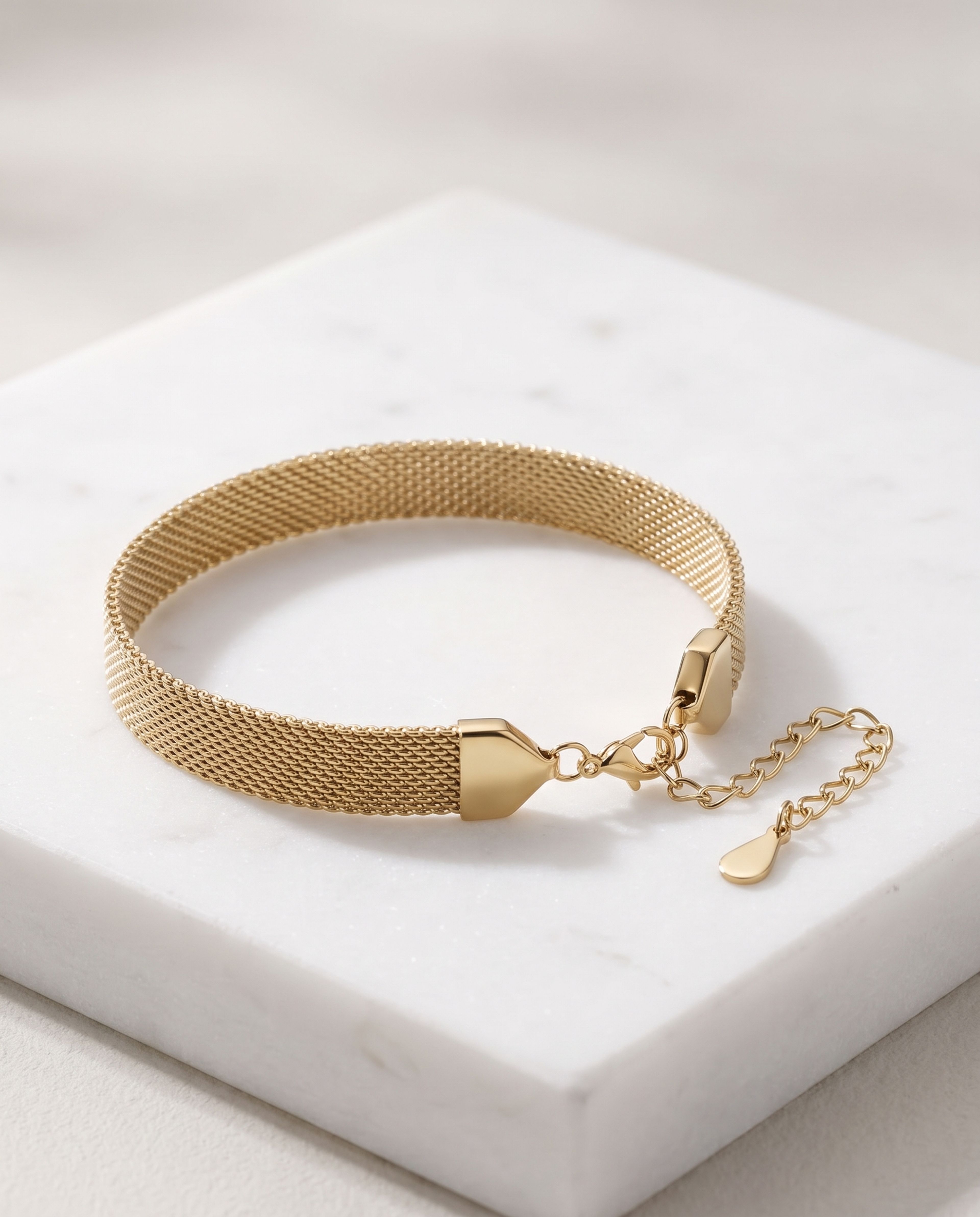 Gold-Tone Stainless Steel Mesh Bracelet laid on white marble