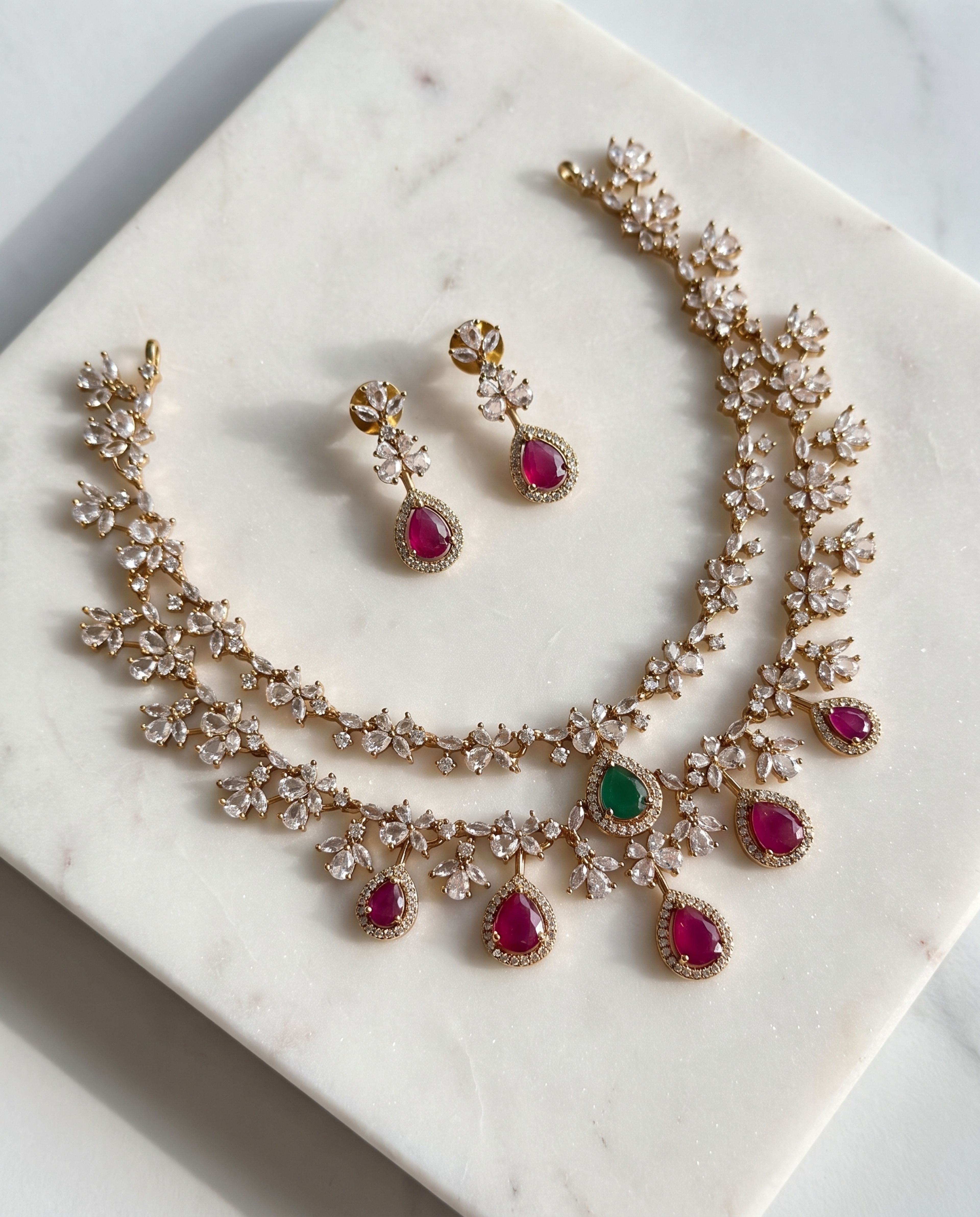 Ruby Green Floral Necklace Set laid on white marble