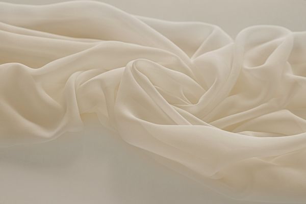 Delikatny muślin w kolorze ivory, układający się w miękkie fale
