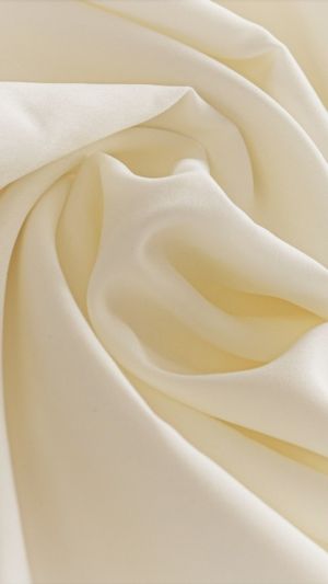 Gładka, elastyczna satyna w kolorze ivory, delikatnie pofalowana na zbliżeniu