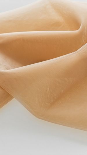 Cielisty lejący tiul elastyczny z delikatnym połyskiem na jasnym tle