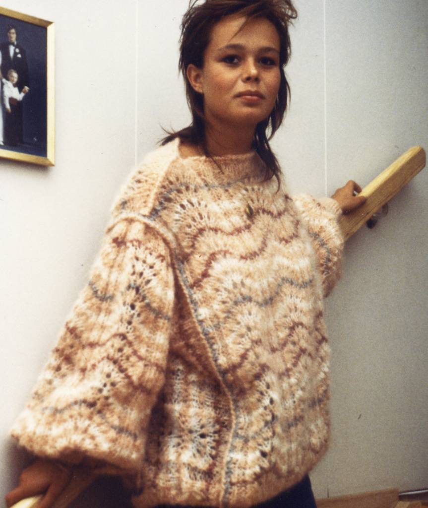 A model wearing a jumper by Knill Design. It's light coloured, loose-fitting, with wave patterns.