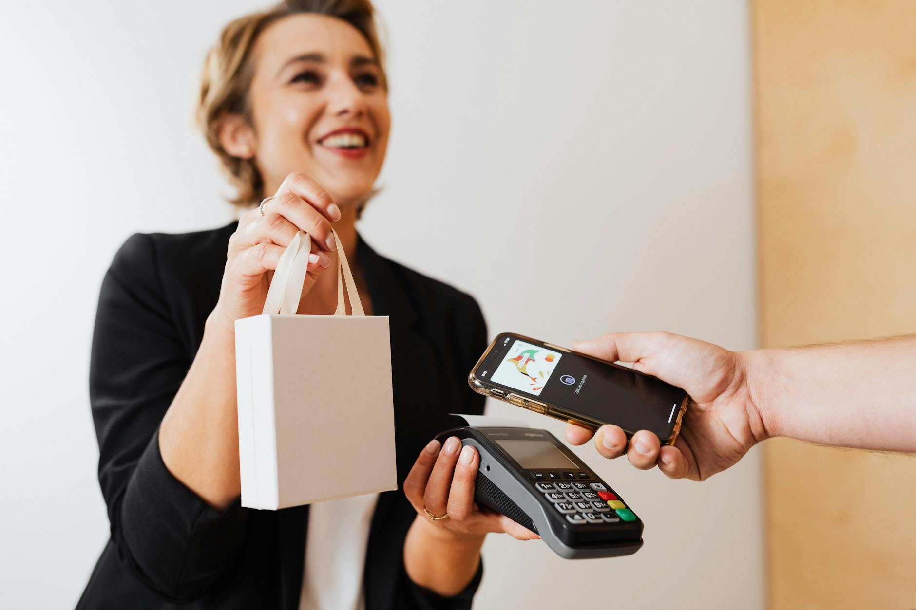 En butikspersonal tar emot mobilbetalning via Swish eller kortläsare direkt vid kundens sida i en svensk butiksmiljö.