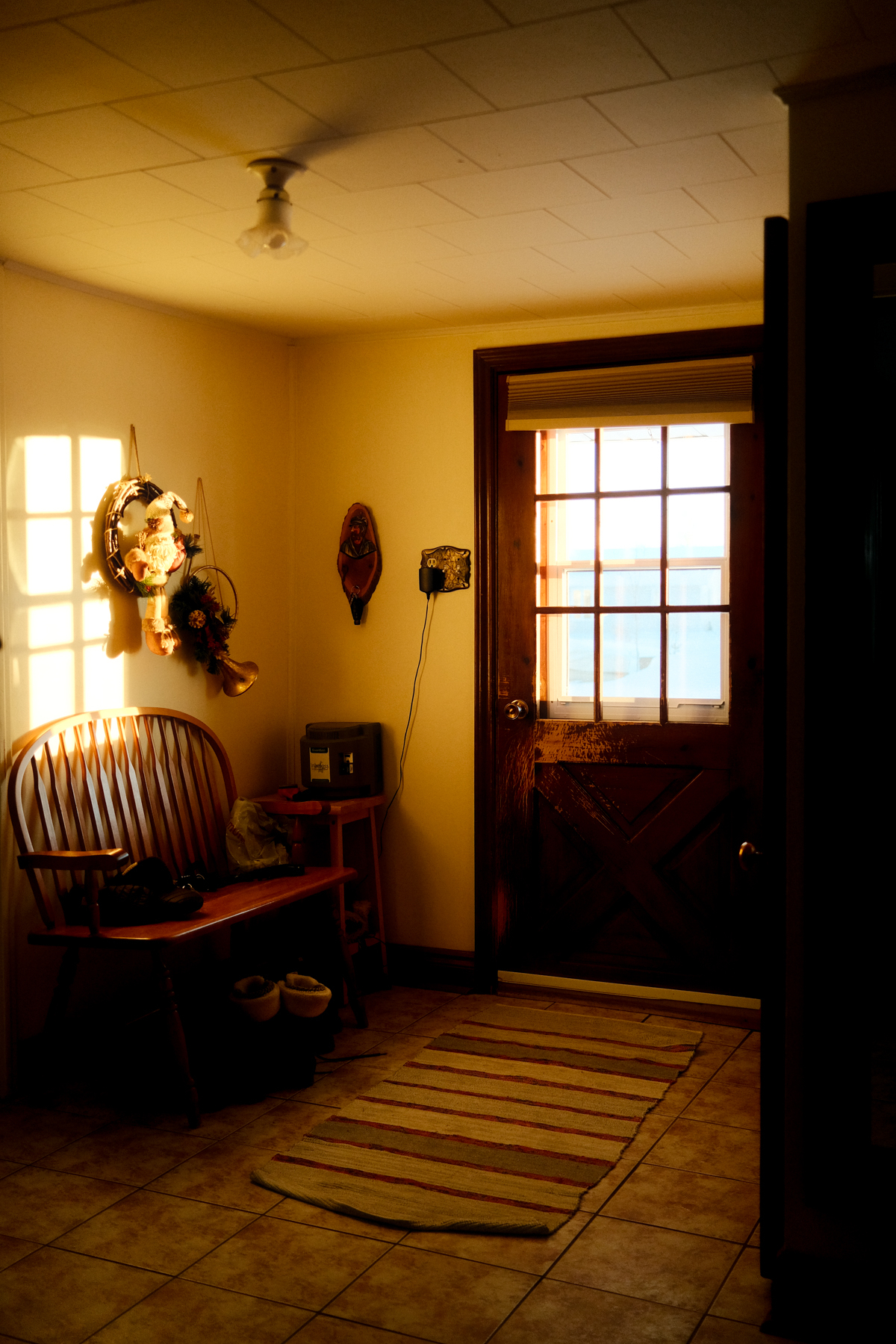 Photo of the entrance of a house with sun shining through the window