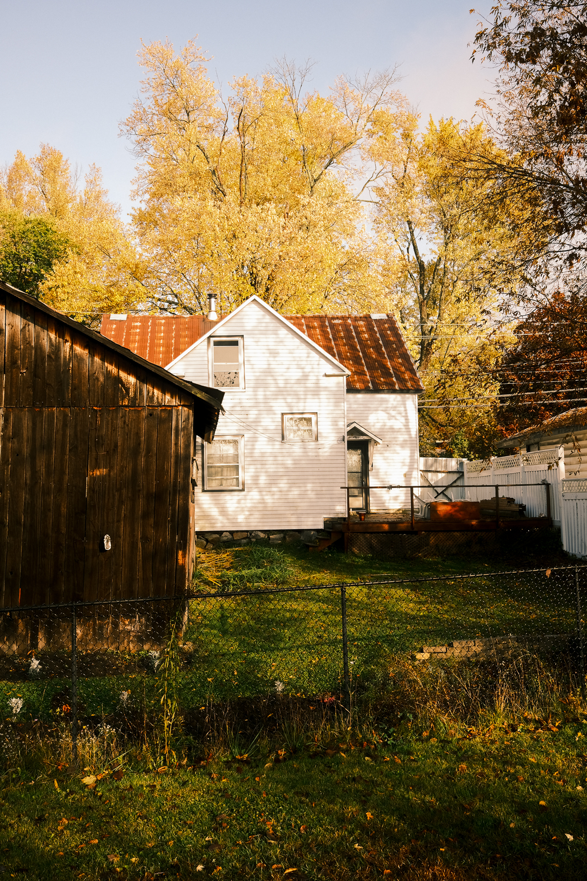 Photo of white house and a barn in the fall