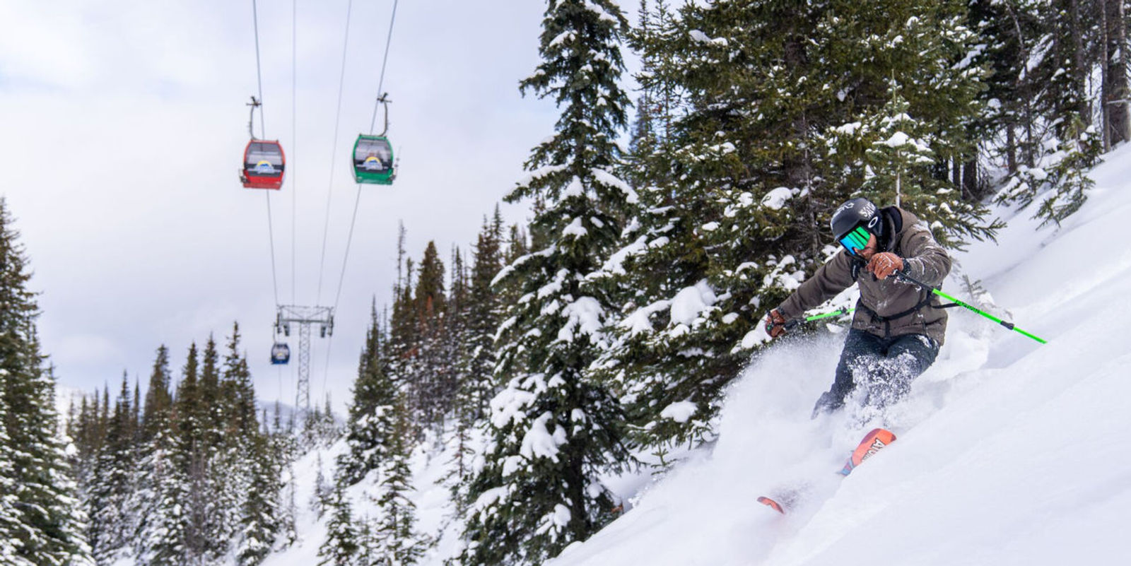 Skier at Banff Sunshine with gondola overhead.