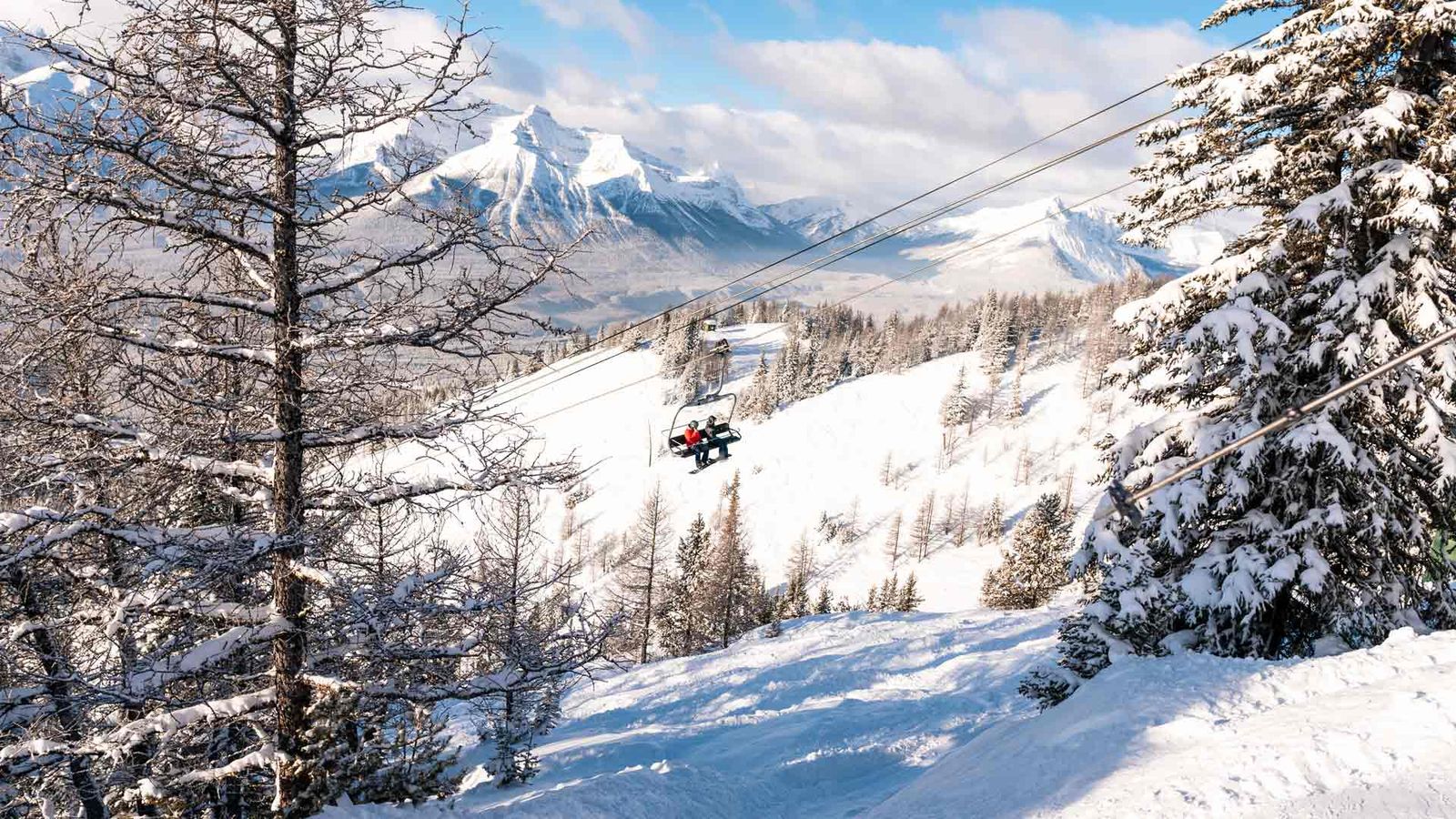 Snowboarders on Top of the World chairlift at Lake Louise Ski Resort in Banff National Park.