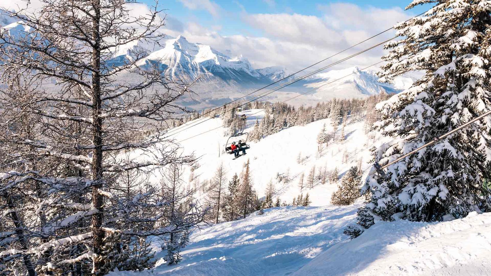 Snowboarders on Top of the World chairlift at Lake Louise Ski Resort in Banff National Park.
