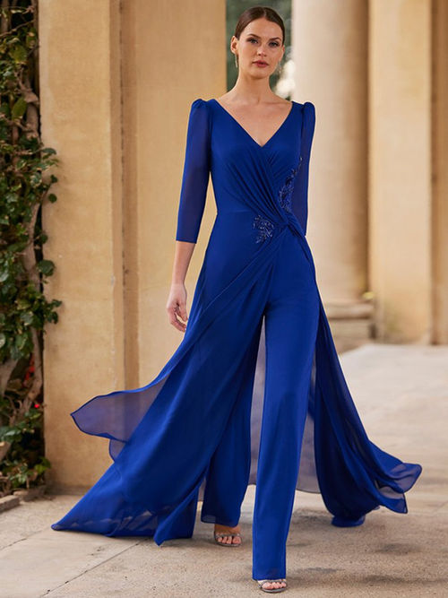 Woman wearing a royal blue jumpsuit as a wedding guest