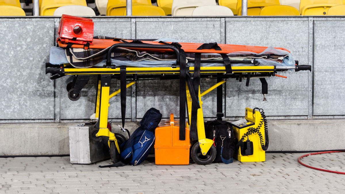 Paramedic ambulance equipment at football stadium for help.