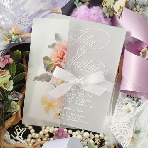 Julia & Matthew created an acrylic wedding invitation with a white bow tied around. Julia & Matthew created an acrylic wedding invitation with a white bow tied around.