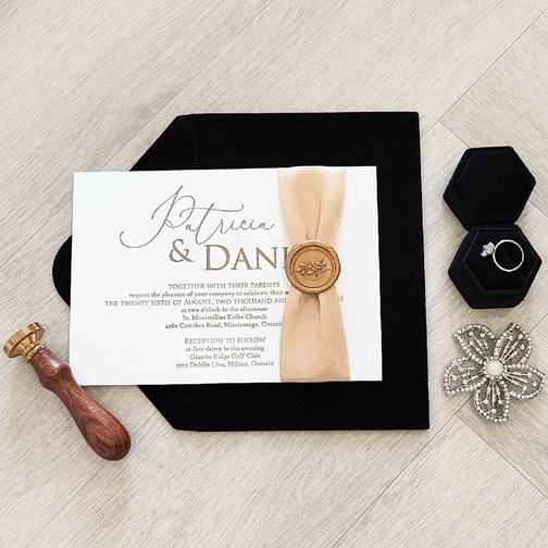 This is a letterpress invitation with a ribbon and wax seal embellishment.  It\'s paired with a black envelope.