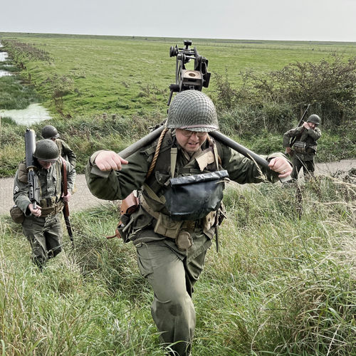 The gunner and assistant gunner, followed by ammunition bearers head off the marshland to secure the coastal defences.