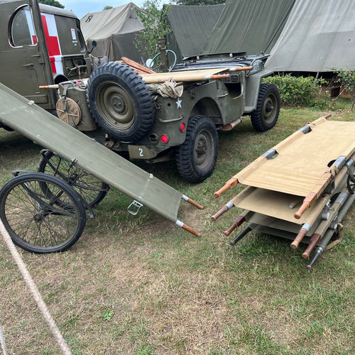 Several US Army Litters (stretchers) ready for use by Hospital staff. A folding collapsible litter carrier can also be seen.