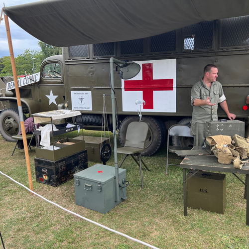 General view of the Mobile Dental Clinic, including a 1942 Operating Lamp, folding field dental chair and a foot-powered drill engine.
