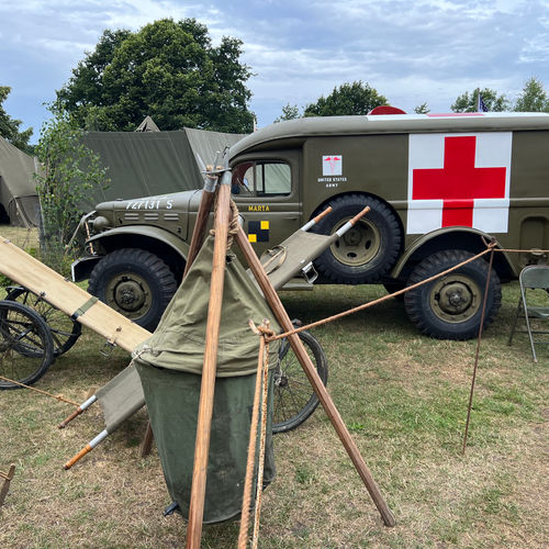 A WC54 Ambulance of the 1st Medical Battalion (1st Infantry Division) arrives at the 128th Evacuation Hospital with new patients. A lyster bag filled with sterilised water is visible in front.