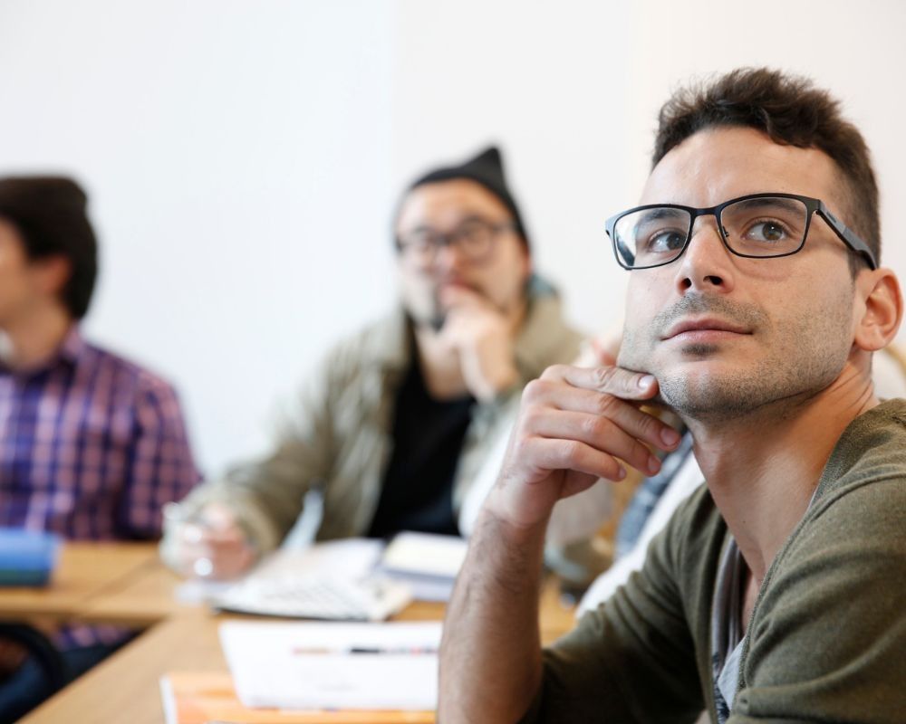 Prima piano di uno studente dell'International House che ascolta la lezione.