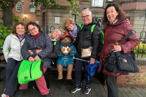 Gruppo di docenti accompagnatrici vicino a una statua dell'orsetto Paddington.