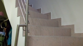Betonové schodiště, keramický obklad a nerezové zábradlí