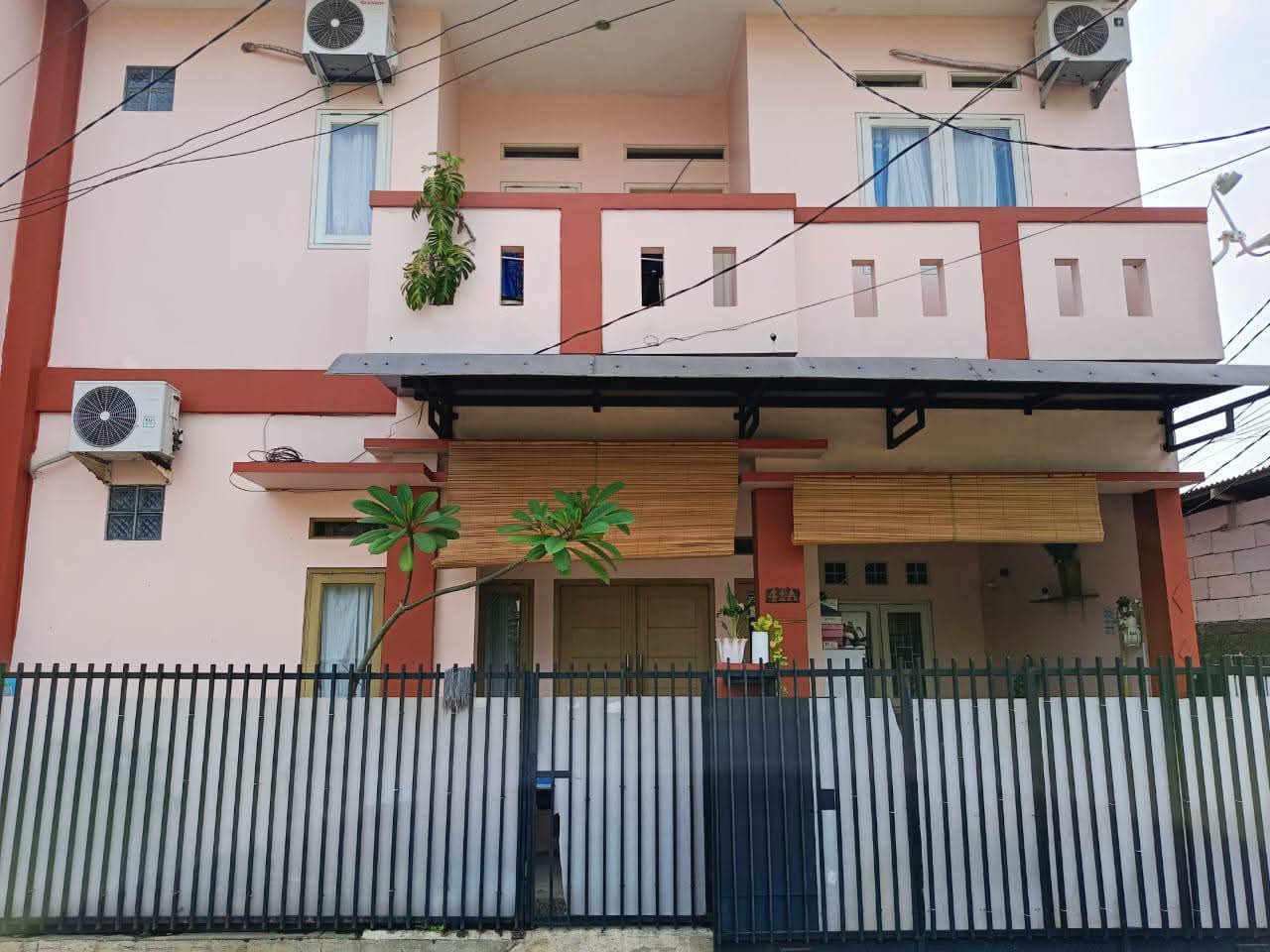Modern wooden sofa with beige cushions in a bright living room with plants and wooden floor