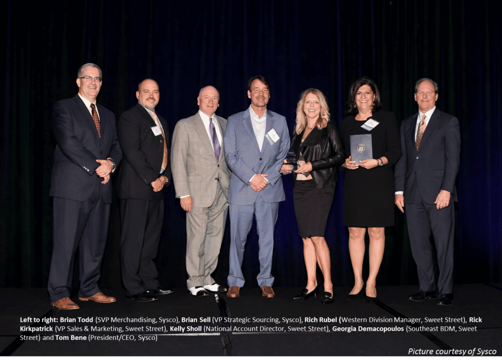 Image of Sysco Leaders and Sweet Street Staff, on stage at awards ceremony. 