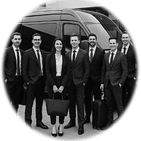 Corporate team in suits standing beside a black van