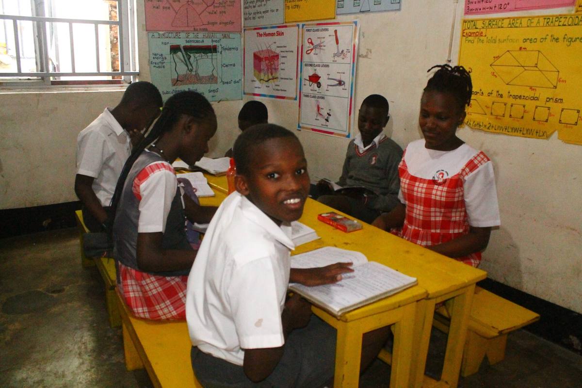 Upper primary pupils revising together at a yellow desk