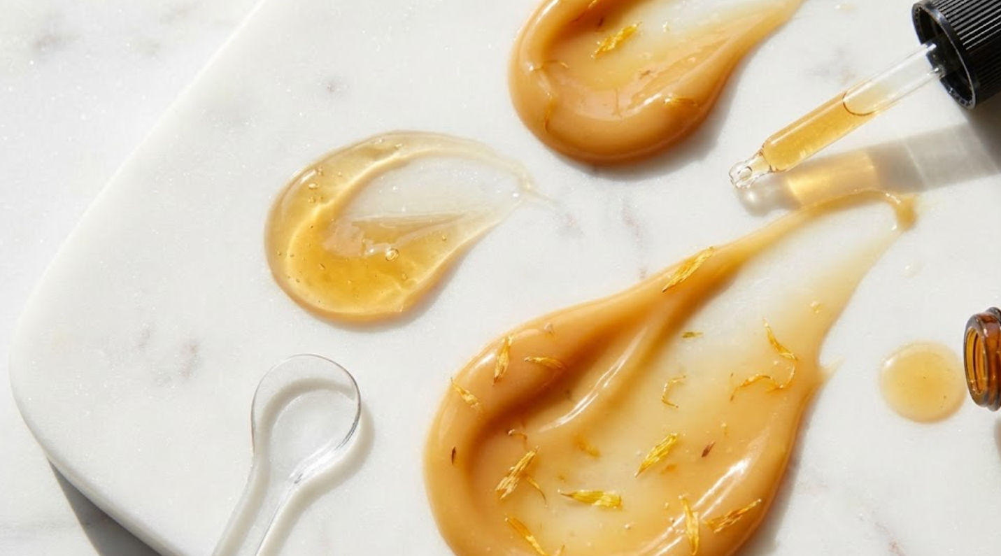 Beneficios calmantes de la línea de caléndula para reducir rojez e inflamación facial Textura de serum y crema facial de caléndula color ámbar para tratamiento calmante de rosácea y piel sensible en Ella Skin & Spa Wellness