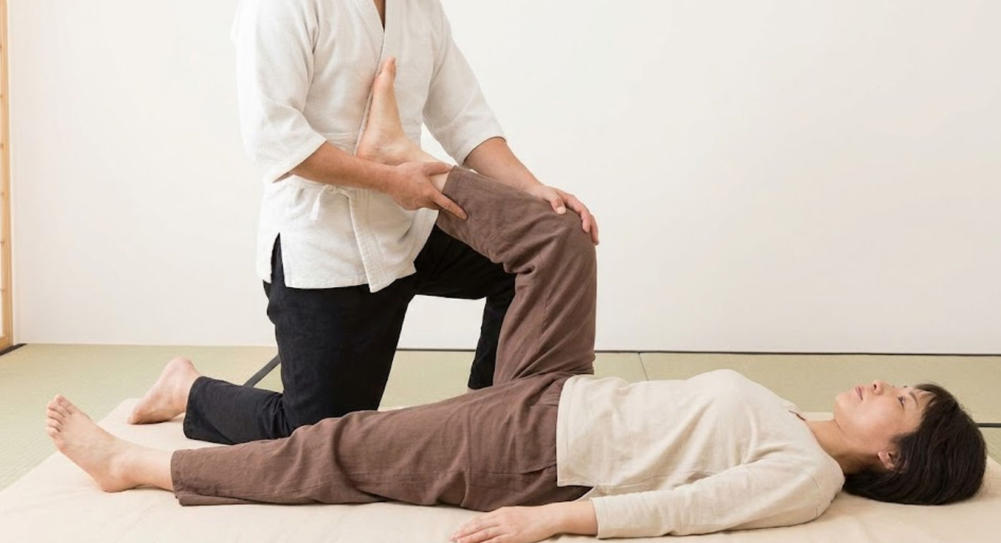 Técnica de masaje tailandés en Mérida realizando estiramientos asistidos de yoga pasivo para mejorar la flexibilidad y flujo energético