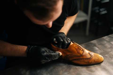 top-closeup-view-professional-shoemaker-wearing-black-gloves-polishing-old-light-brown-leather-shoes.webp