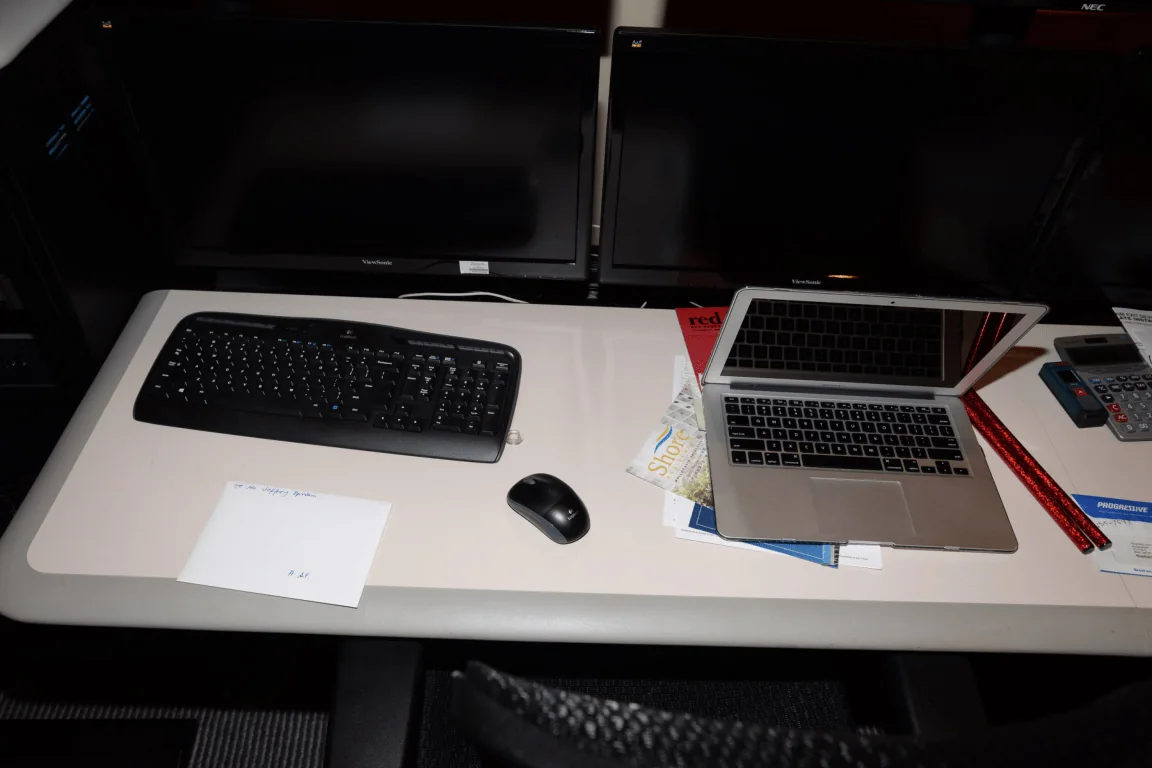 A person works at a multi-monitor computer workstation.