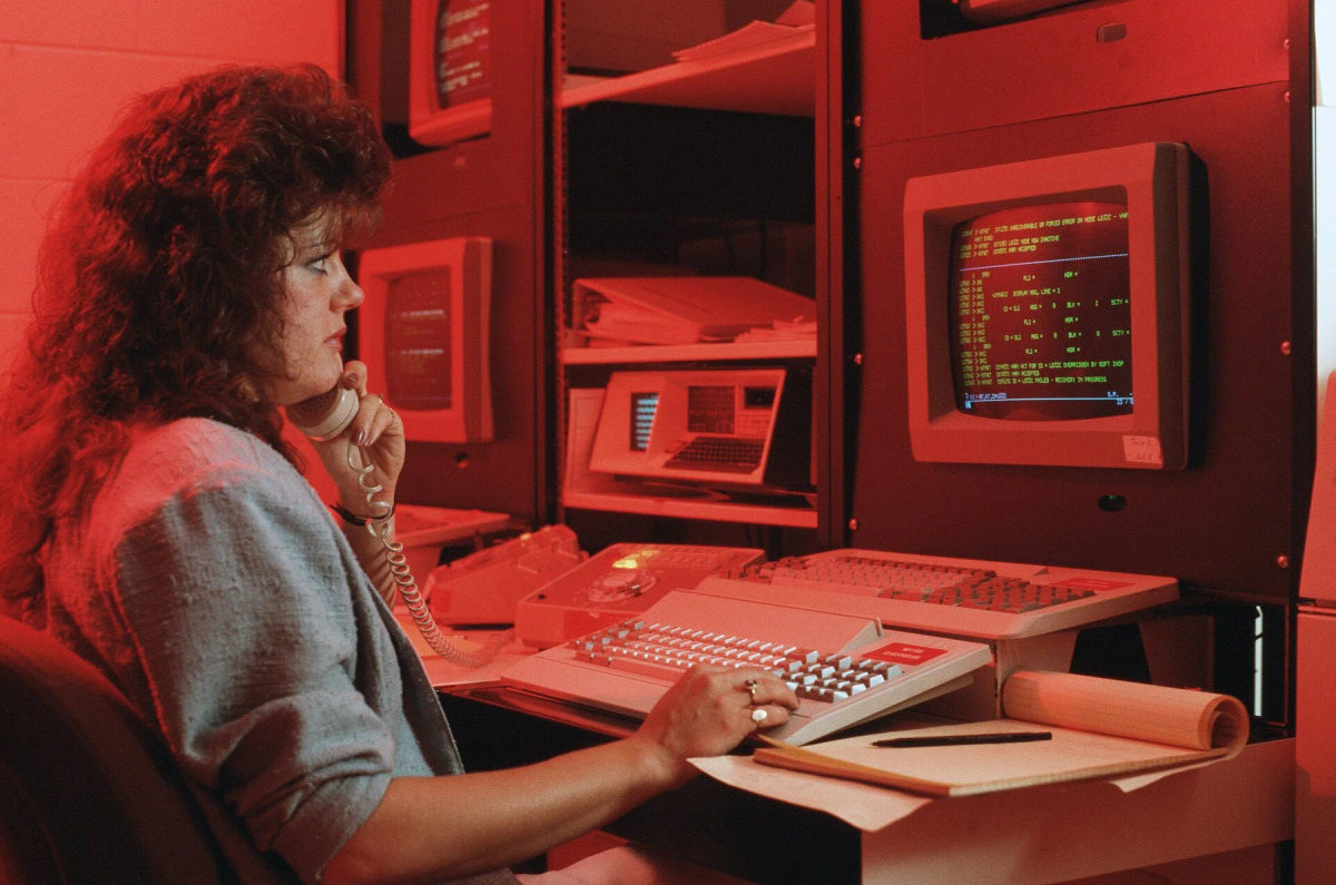 A technician works at a computer console in a communications center.