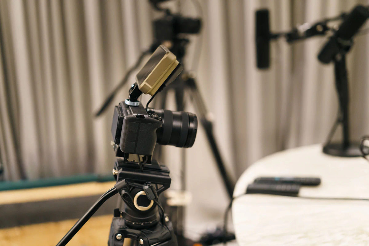 A camera and microphone are set up in a podcast studio.
