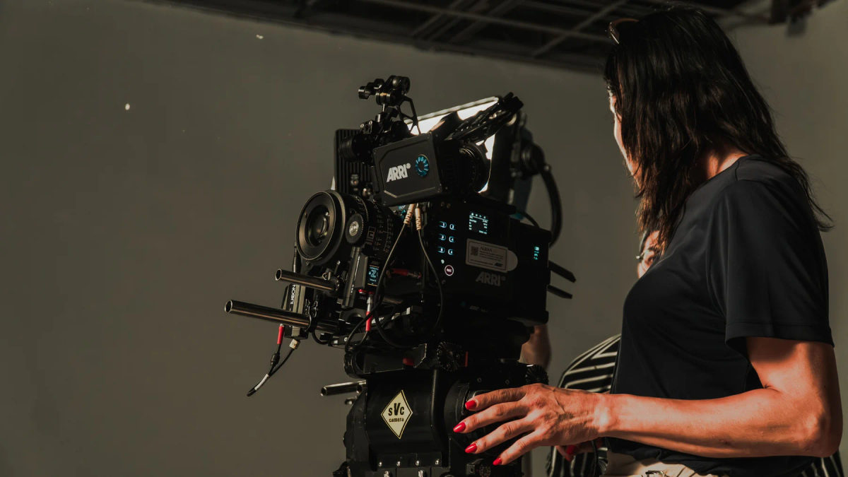 A film crew operates a camera rig in a studio.