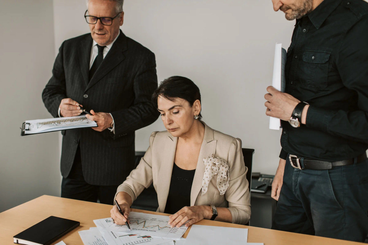 Business professionals collaborate over financial documents in an office.