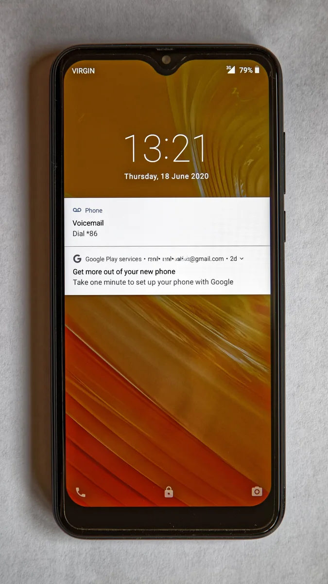 A black smartphone is shown from the front with its lock screen visible.