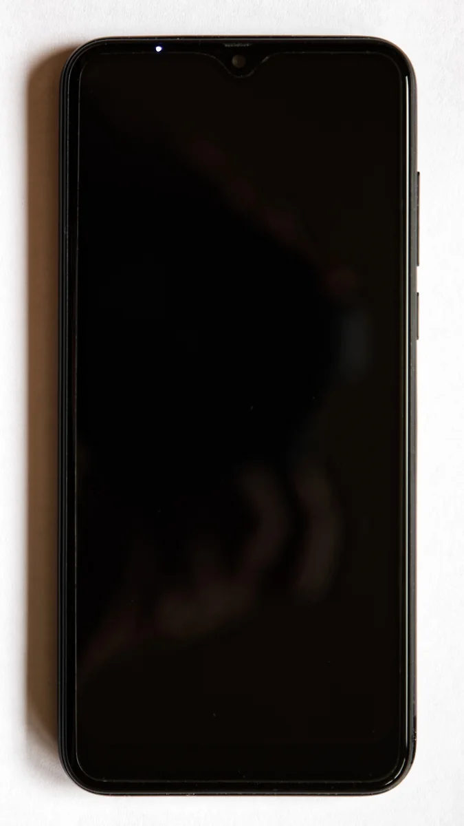 A black smartphone is shown from the front with its screen on standby.