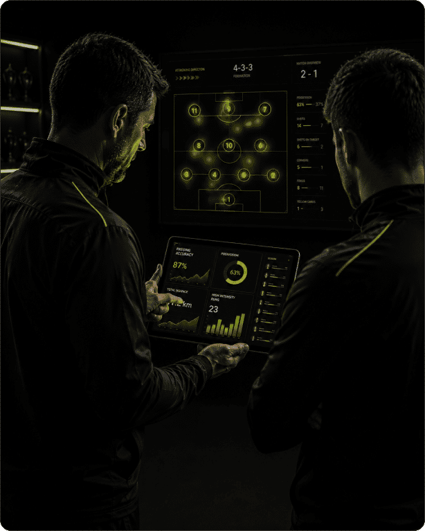 Two coaches reviewing a live match-analytics dashboard on a tablet