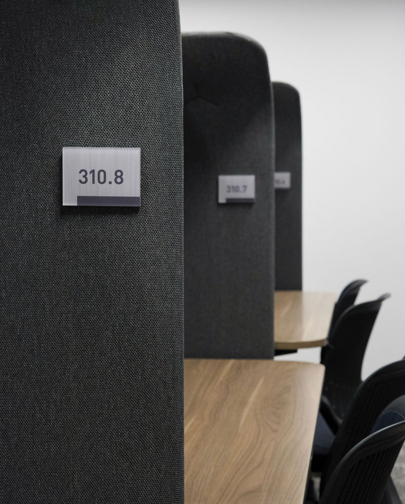 A row of workstations marked with custom printed Vivid nameplate signs