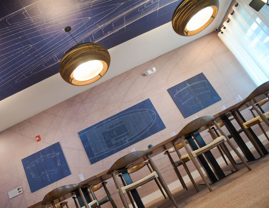 A contemporary hospitality dining room featuring acoustic wall panels and custom wallcovering on the walls and ceiling.