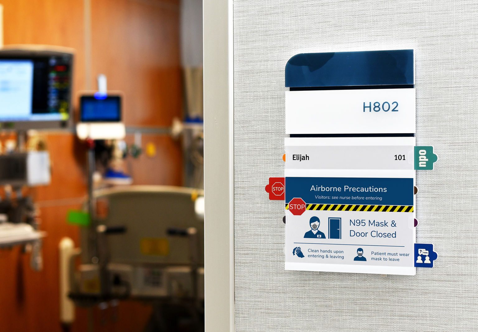 ADA-compliant nurse-alert patient room sign with tamper-resistant alert tabs and replaceable insert designed and fabricated to meet the hospital's sign standard.