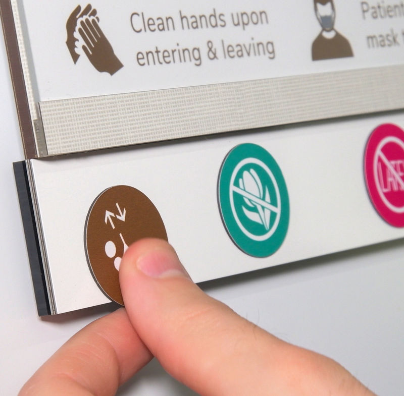 Close-up of an alert magnet being applied to an Attend nurse alert patient room sign.