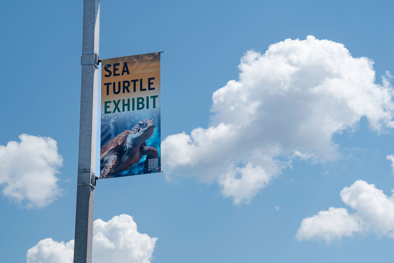 An exterior banner attached to a parking lot pole of an aquarium.