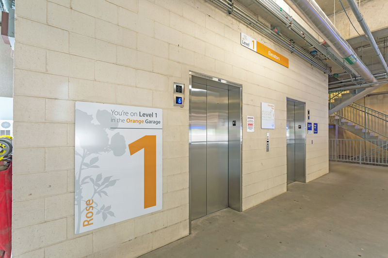 Parking and wayfinding signage adjacent to garage elevators.