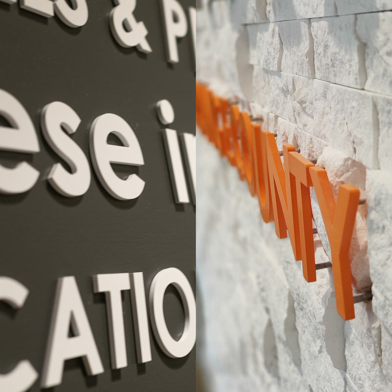 Comparison of flush-mounted dimensional letters and stand-off lettering installation.