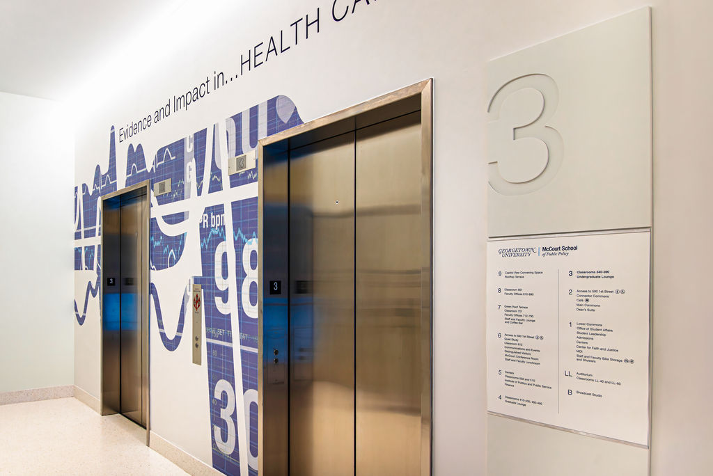 A level indicator with updatable paper insert beside an elevator door.