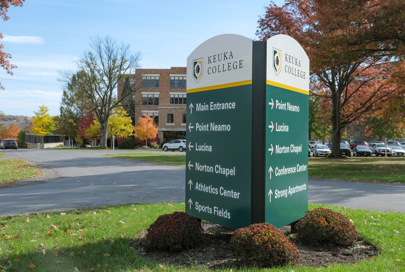 A large three-sided vehicular directional exterior sign on a college campus