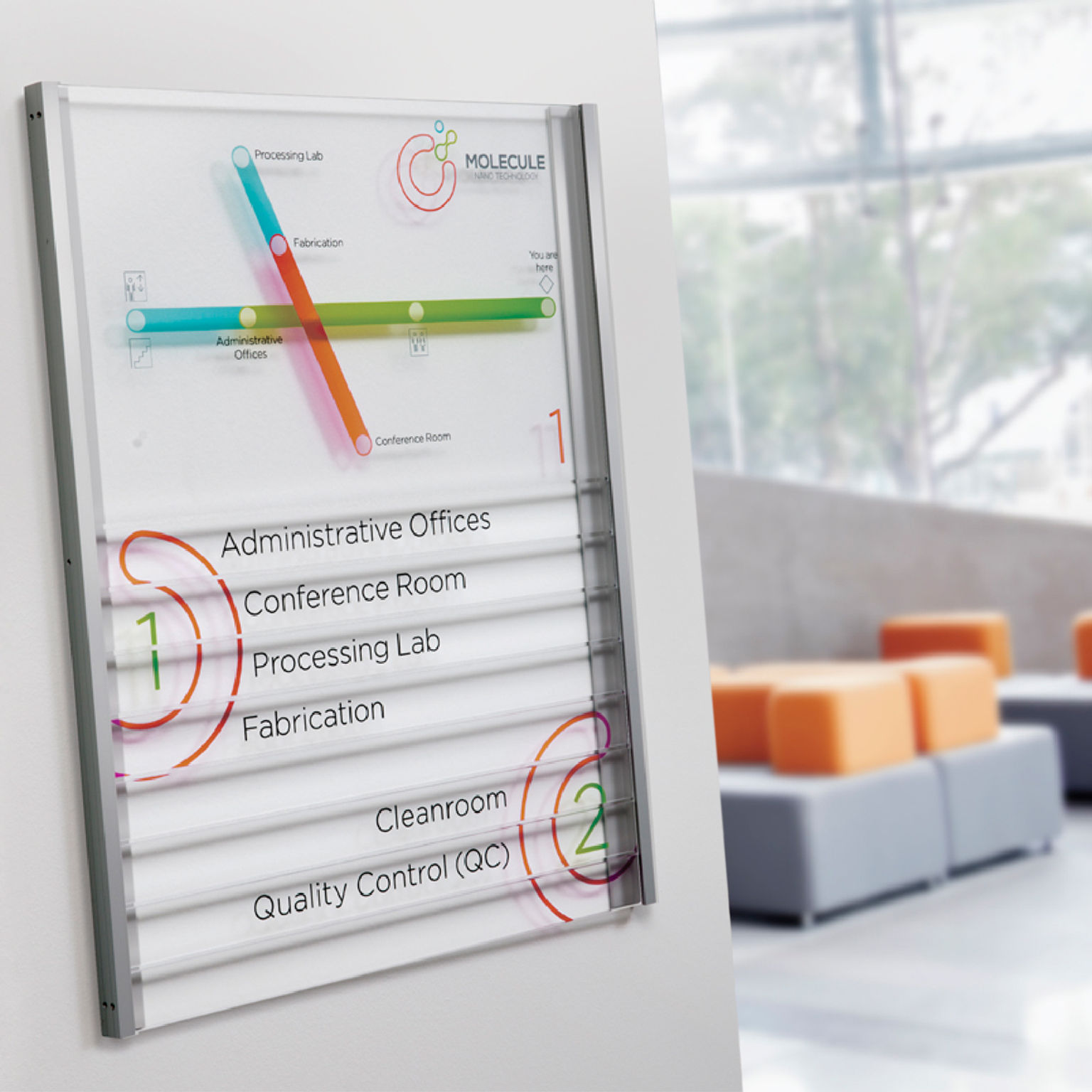Contemporary multi-component metal and glass-look updateable directory sign with colorful geometric brand graphics.