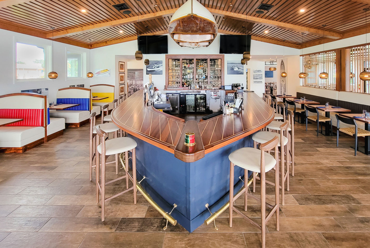 The custom bar in the shape of a boat and booth seating area designed with boating themed graphics and upholstery..